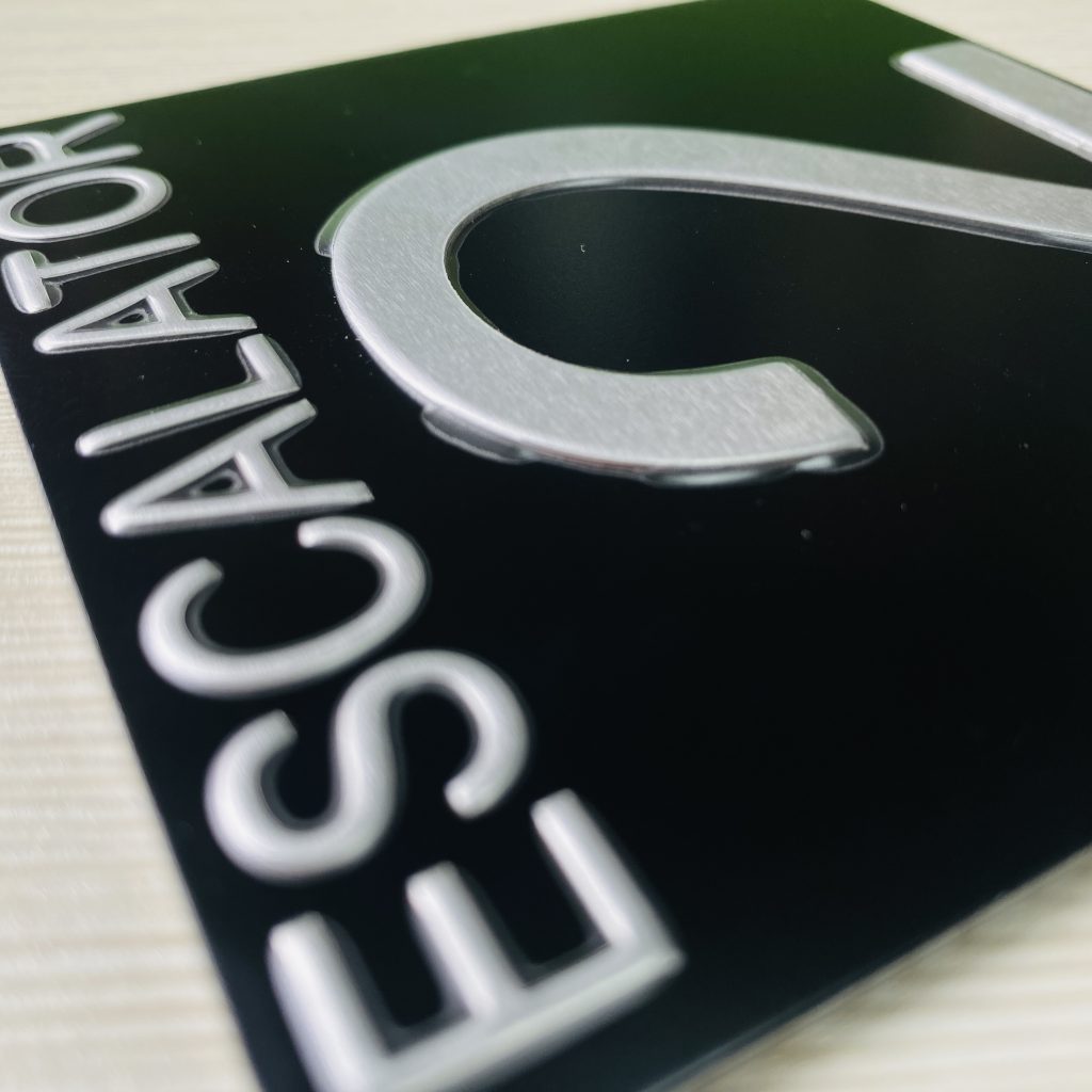Brushed aluminum write-on zone on elevator nameplate