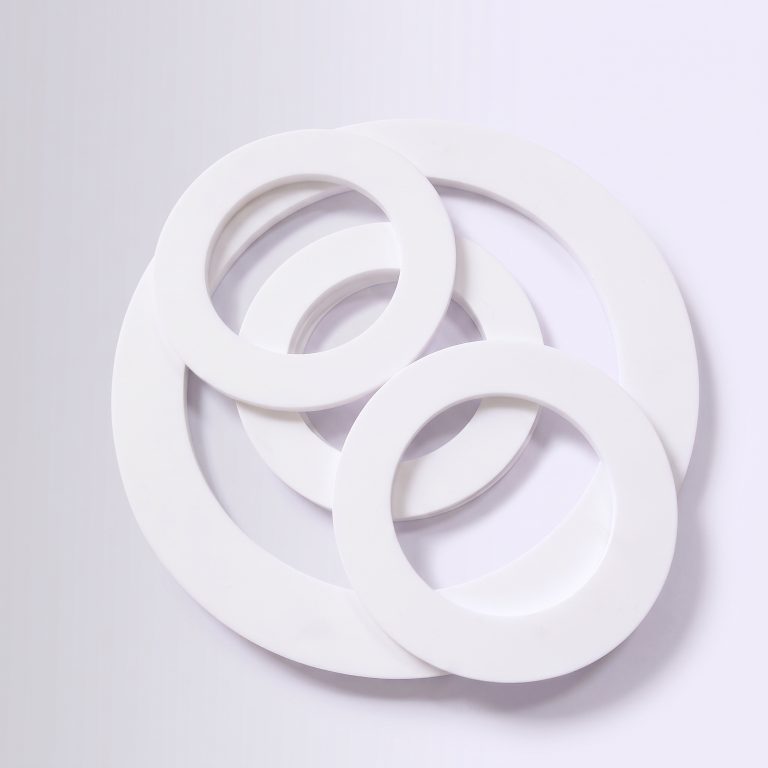 three flat white ptfe teflon flange gaskets on brand background bx panel